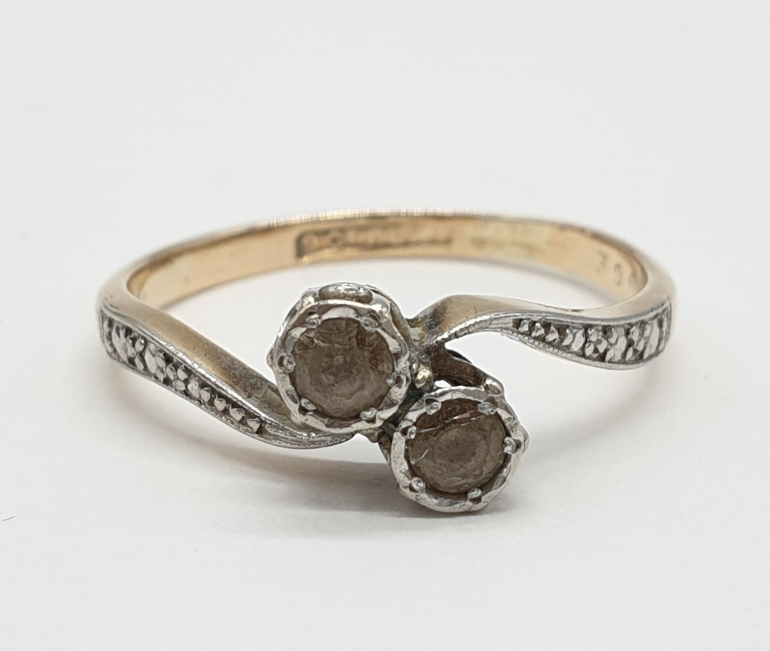 9ct Gold and platinum ring having two pale aqua stones to top in crossover style. Preserved in