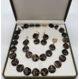 A 60?s black and gold coloured necklace, bracelet and earrings set in a presentation box. Necklace