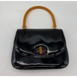 Gucci styled black patent handbag with orange resin handle and clasp. Bag measurement w24 x h19cm.