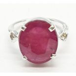 A 11ct Ruby gemstone ring in sterling silver with two diamond accents. Weight 5.67g, Size Q.