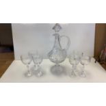 A heavy cut glass decanter with 6 matching glasses