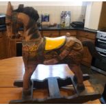 A vintage hand carved and hand painted children's wooden rocking horse. 90cm high x 80cm wide.
