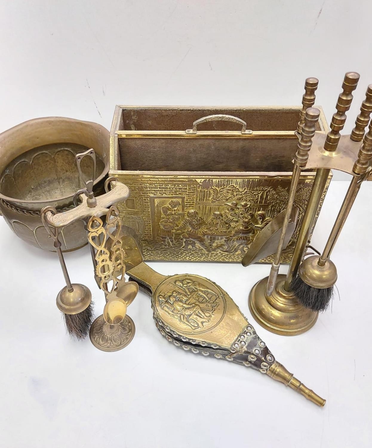 A bronze selection of vintage fireside utensils including decorated brass bellows.