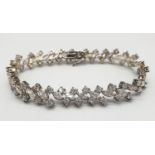 Silver tennis bracelet with stones set in trilogy form along the length of the bracelet. Bracelet