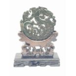 A Chinese, hand carved on both sides and pierced, dark green jade amulet, representing mythical