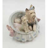 A Lladro porcelain figurine of Terrier dogs in basket. Good condition. 10 x 13cm.