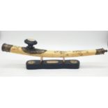 An antique Chinese opium pipe, made of water buffalo bone, on a custom made base made of wood and