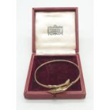 A Harrods Vintage 9ct Gold Bangle with Dolphin design clasp. Comes in box, 4.16g. 6cm diameter (