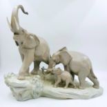 This spectacular Lladro porcelain piece depicts a family of elephants ascending a rock-led by a