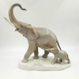 A Lladro porcelain figuriene of a mother and baby calf elephant. Slight damaged to one of the tusks.