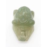 Hard stone belt buckle in the form of an Asian god. 79g in weight, 7cm x 5cm.