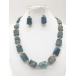 A necklace and earrings set made of Brazilian bluish apatite in its natural state. In a gift box,