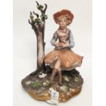 A Capodimonte figure of a pretty girl playing with birds.