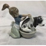 A Lladro porcelain figurine of a young girl washing her dog. Good condition. 14x13cm.