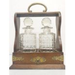 An Edwardian decanter tantalus cabinet; including two decanter bottles. Comes with key.