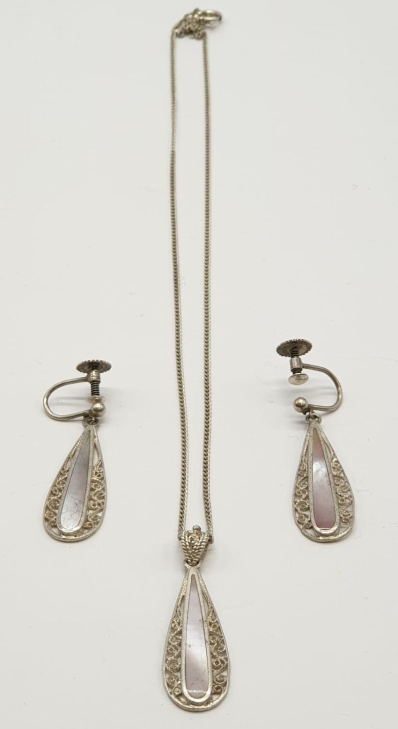 Silver jewellery set to include pendant on chain and matching pair of earrings. Mother of pearl