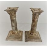 Pair of antique silver candlesticks having Corinthian pillars on a beaded base with ornate