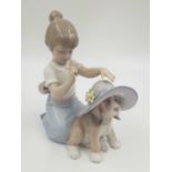 A Lladro porcelain figurine of a girl patting a dog. 16cm high. Good condition.