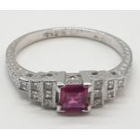 An art deco style ladies 18ct white gold diamond and ruby (emerald cut) ring. Size N.0.3ct ruby.