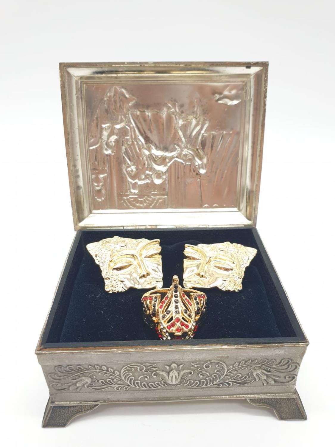 A ring depicting a Venetian Carnival Mask and a pair of earrings in a metal, Renaissance style