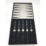 A mini magnetic backgammon board with pieces. 14cm x 14cm.