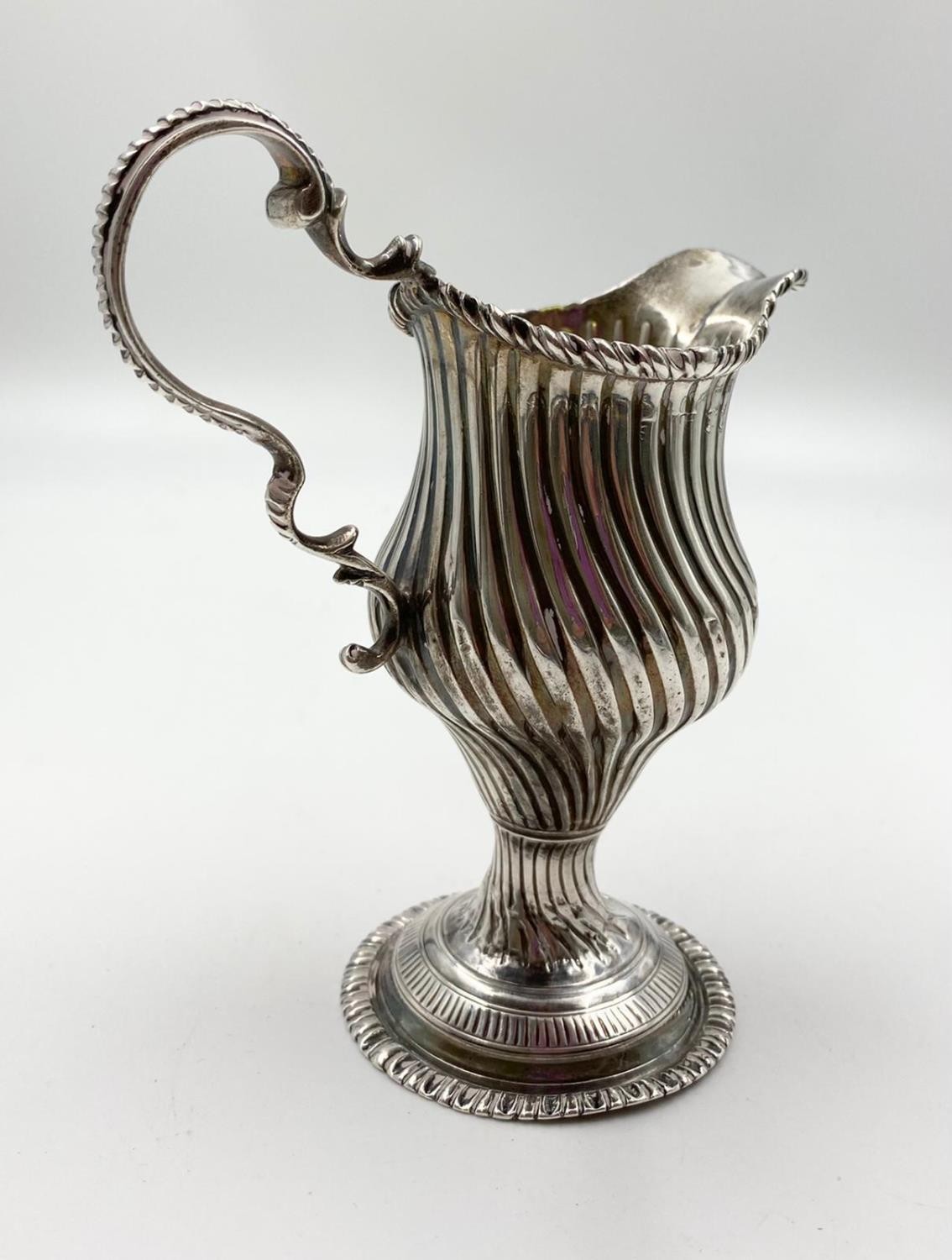 A finely detailed silver creamer in ribbed swirl pattern with curved handle on a pedestal base. 14cm - Image 4 of 4