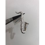 18ct white gold brooch saxophone with diamonds around 0.22cts. 7.7 grams in weight, length around