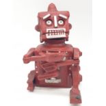 A cast iron, mechanical, money box in the shape of a robot. With moving hands, jaw and eyes. In
