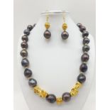 A statement necklace and earrings set with rare, baroque, black pearls and Chinese, gold filled