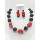A Hawaiian lava necklace and earrings set, adored with big chunks of Pacific red coral. In a