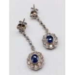 Pair of 14ct White Gold Drop EARRINGS with brilliant cut Diamonds and central Sapphire. 6.6g 3cm