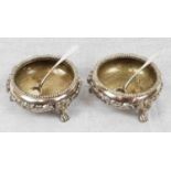 A Pair of Antique Silver Salts with Spoons. Circular with Lion Monopod supports, linked with
