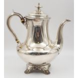 An Antique Silver Coffee Pot, sitting on ornate decorated claw-feet. Classic design with slight wear