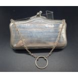 An early white-metal elegant purse. Attached to a white-metal chain with cloth interior. 12 x 8cm.