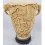 A FINELY CARVED CHINESE VASE WITH ELEPHANT HEADS AS HANDLES AND SCENES OF FAMILY LIFE MADE TO LOOK