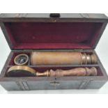 An antique explorer?s basic kit including a compass, a 4 draw telescope and a magnifying glass, in a