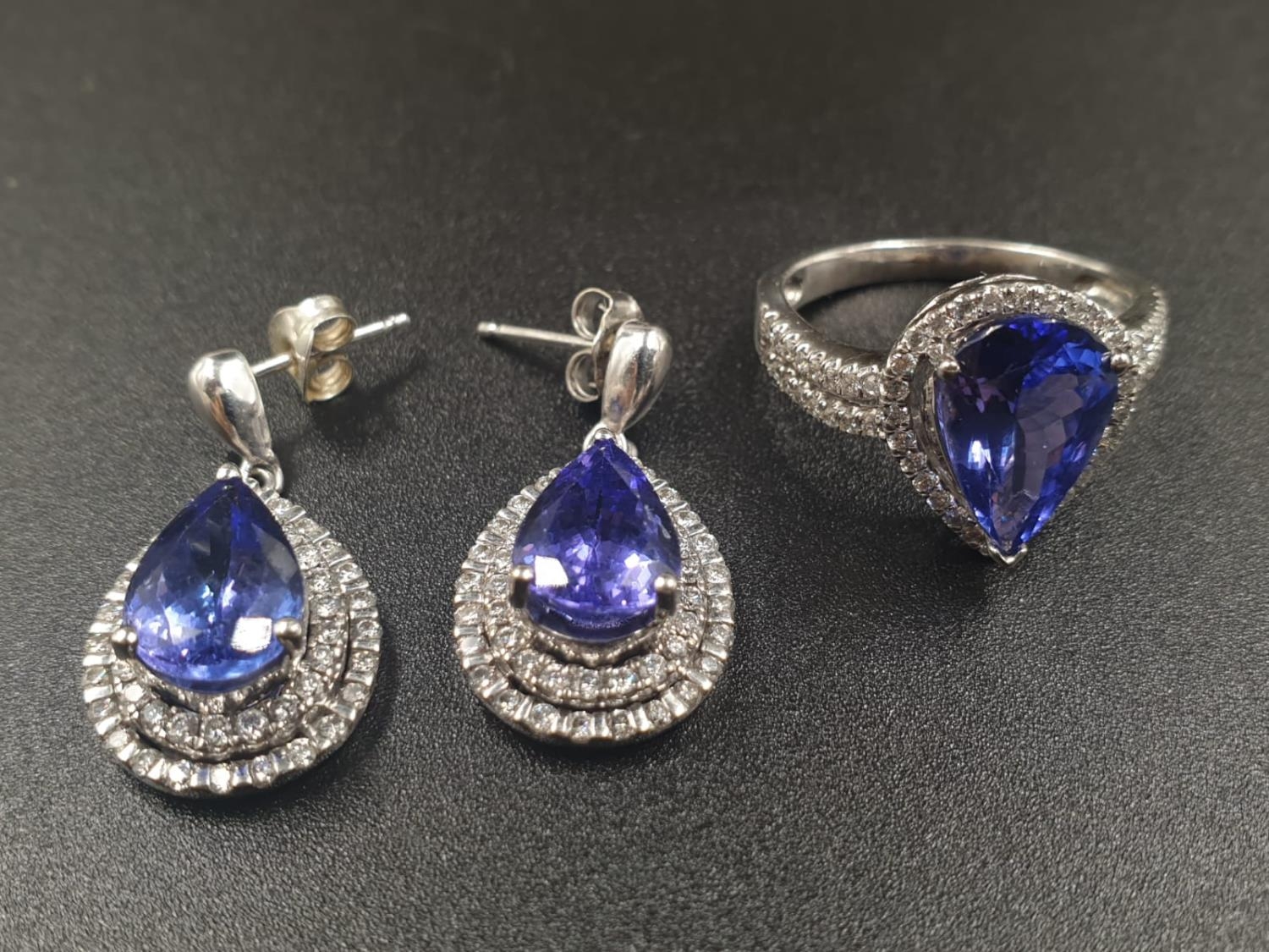 A 14CT WHITE GOLD MATCHING SET OF EARRINGS AND DRESS RING WITH LARGE PEAR SHAPED TANZANITE STONES