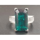 A PLATINUM RING WITH A LARGE 8.5CT SYNTHETIC EMERALD WITH 12 NATURAL DIAMOND ON THE SHOULDERS