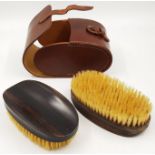 A Pair of Ebony Clothes Brushes that come in a Leather Case.