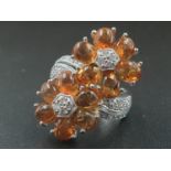 A MODERN DESIGN CROSS OVER RING IN 18CT WHITE GOLD WITH DIAMONDS AND QUALITY CITRINE . 10.8gms