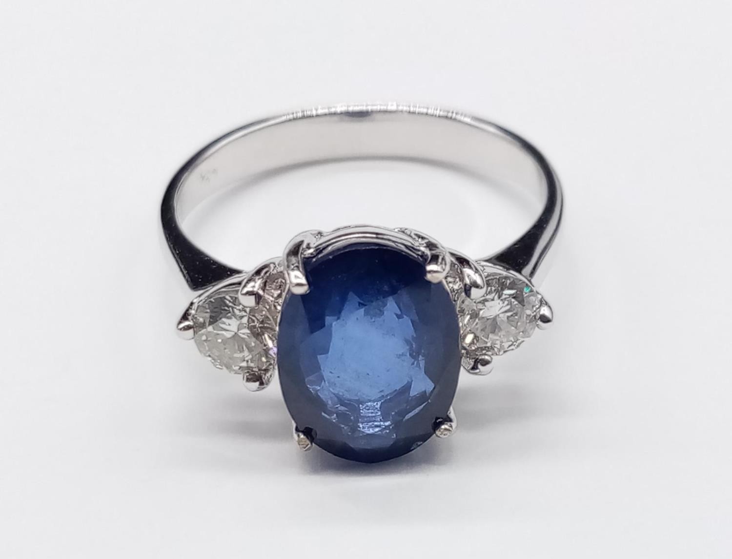 18ct White Gold RING set with one oval cut natural Sapphire and 2x round brilliant cut natural