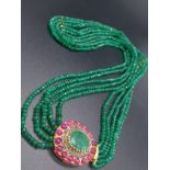 A Five Row Green Onyx necklace with a Ruby clasp cum brooch with a halo of diamonds and rubies ,