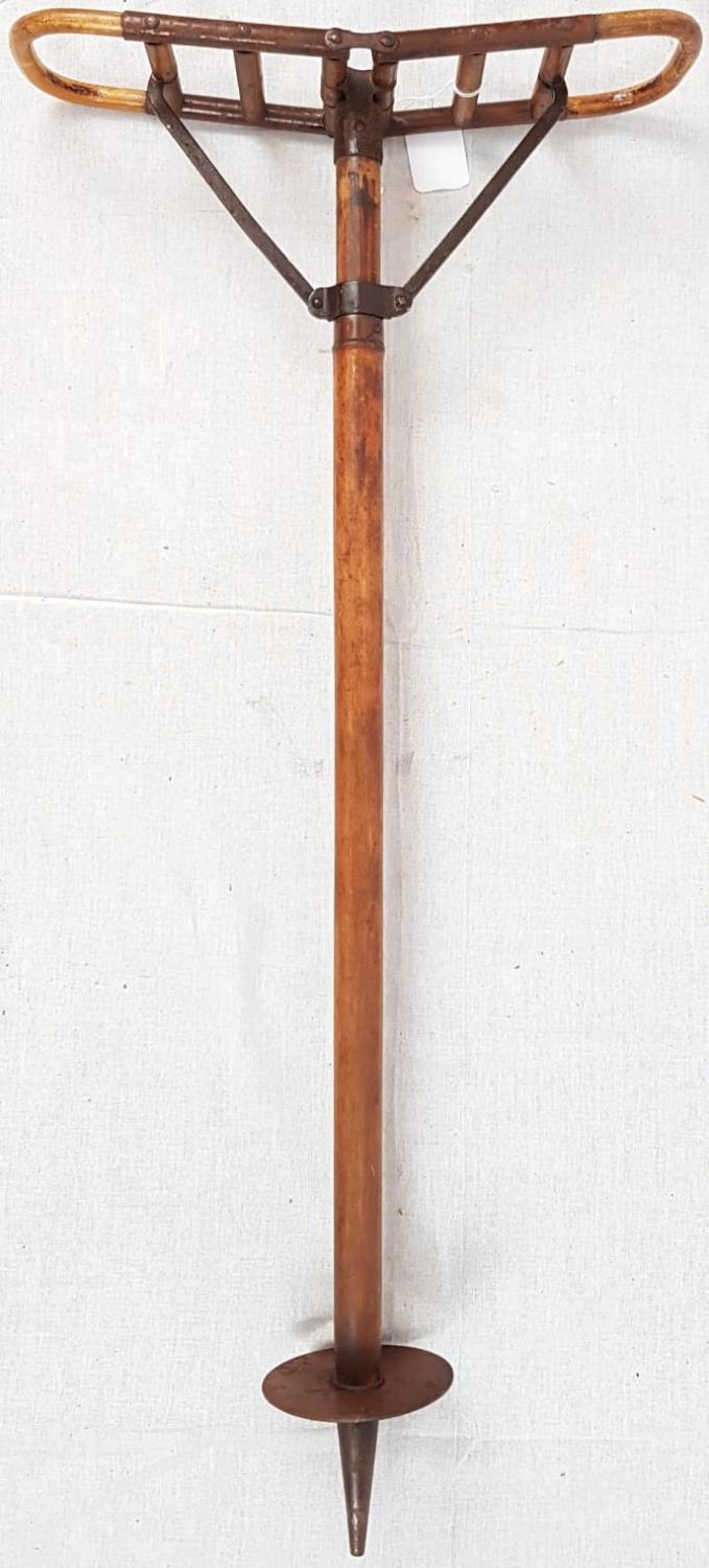 A 1920'S WOODEN SHOOTING STICK WITH METAL HINGES AND SUPPORTS. A LEANING HEIGHT OF 66cms