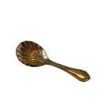 A stunning example of a George Adams silver caddy spoon having a bowl in shell form with a clear