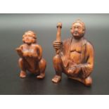 A double Japanese intricately carved boxwood netsuke representing. The Master of pleasure holding