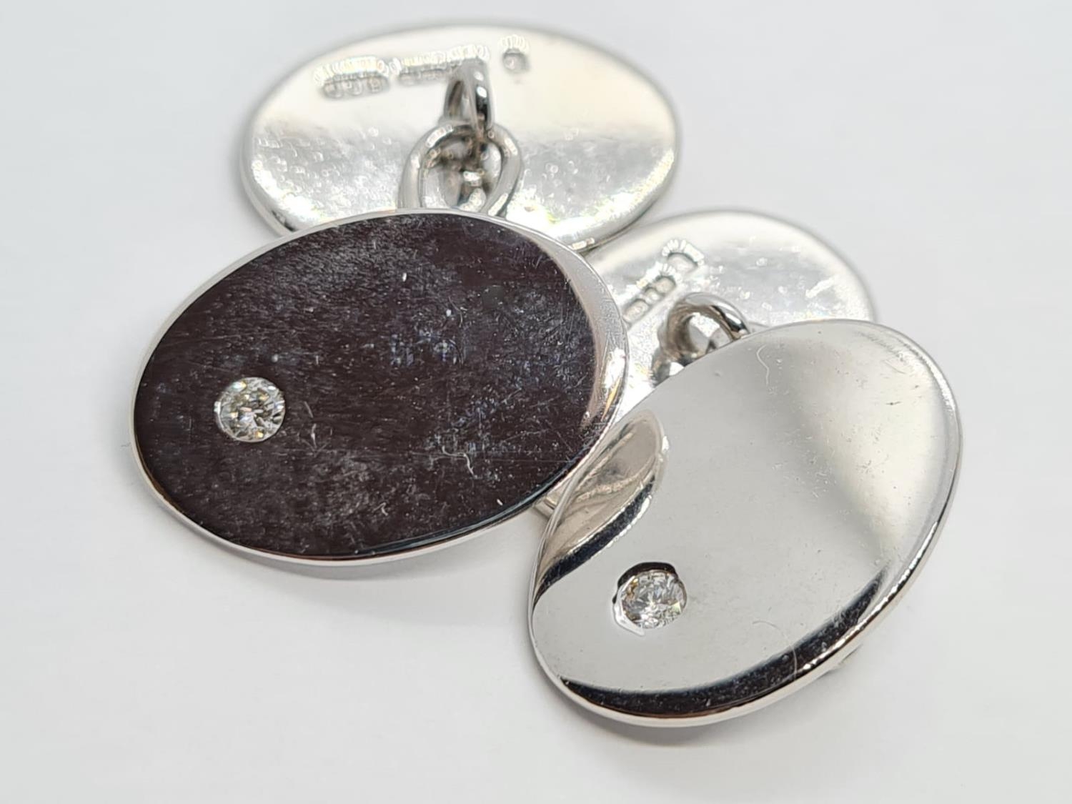 a pair of 18k white gold cuff links with a set diamond . 15.7gms