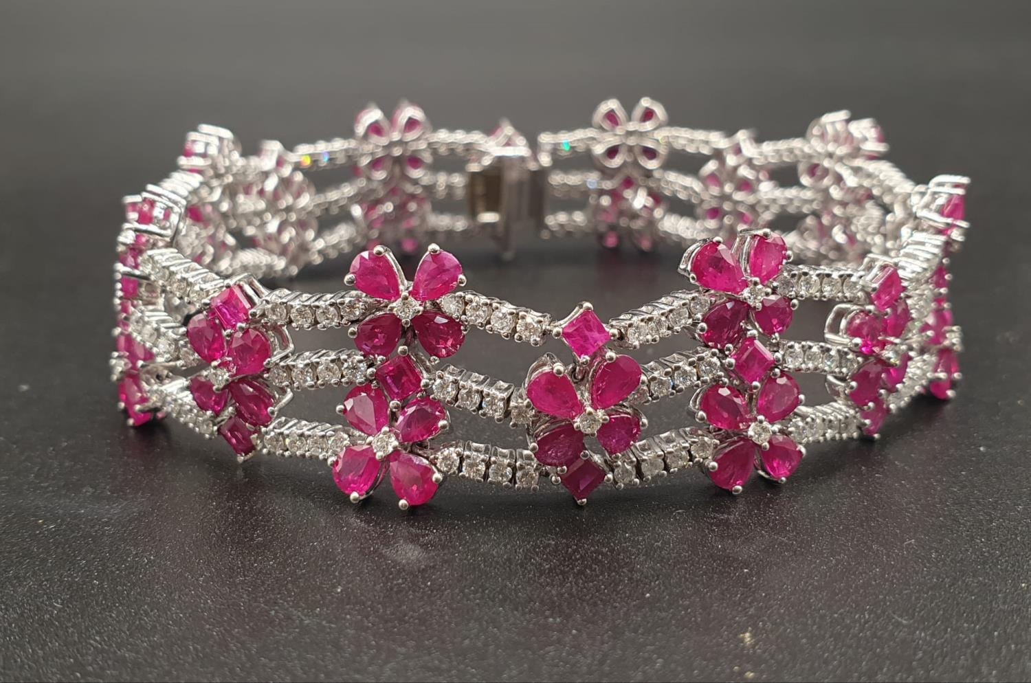 AN EXTREMELY ATTRACTIVE 3 ROW 18K WHITE GOLD BRACELET WITH ENCRUSTED DIAMONDS AND DECORATED WITH A