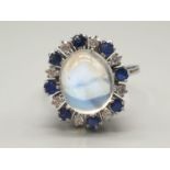 18k white gold ring set with a large moonstone/sapphire centre and surrounded by diamonds and