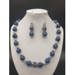 A Tibetan Buddhist lapis lazuli necklace and earrings set in a presentation box. Necklace length: