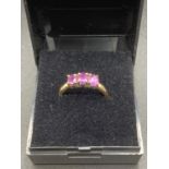 9 carat gold trilogy ring ,having three amethyst coloured stones to top . Full UK hallmark to inside